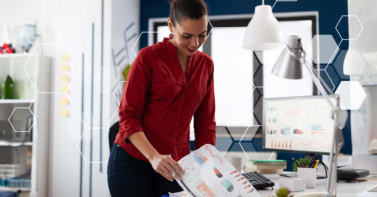 A woman looking at a stack of charts on paper